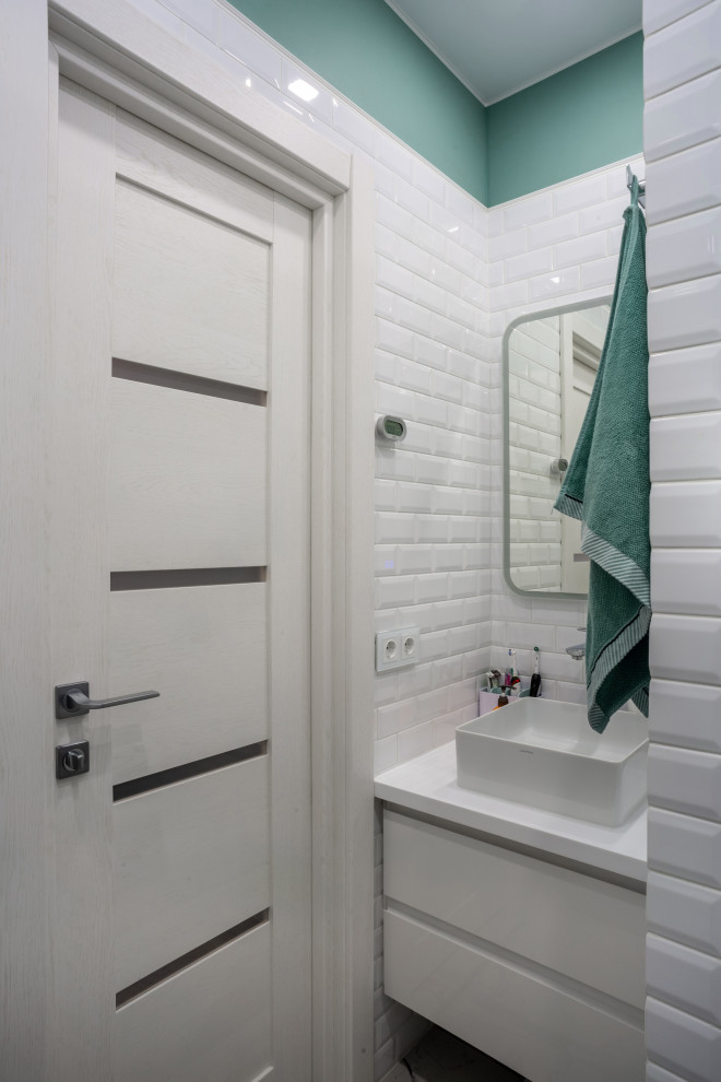 На фото: маленькая ванная комната в стиле неоклассика (современная классика) с плоскими фасадами, белыми фасадами, белой плиткой, керамической плиткой, зелеными стенами, настольной раковиной, бирюзовой столешницей, тумбой под одну раковину и подвесной тумбой для на участке и в саду