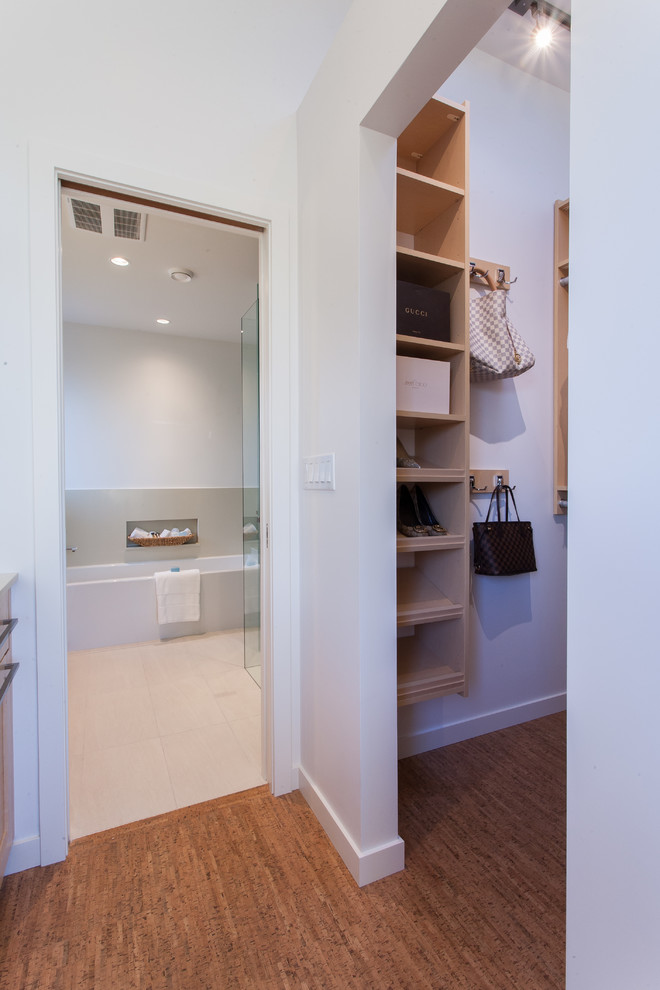 Photo of a small contemporary gender-neutral walk-in wardrobe in Vancouver with open cabinets, light wood cabinets and cork floors.