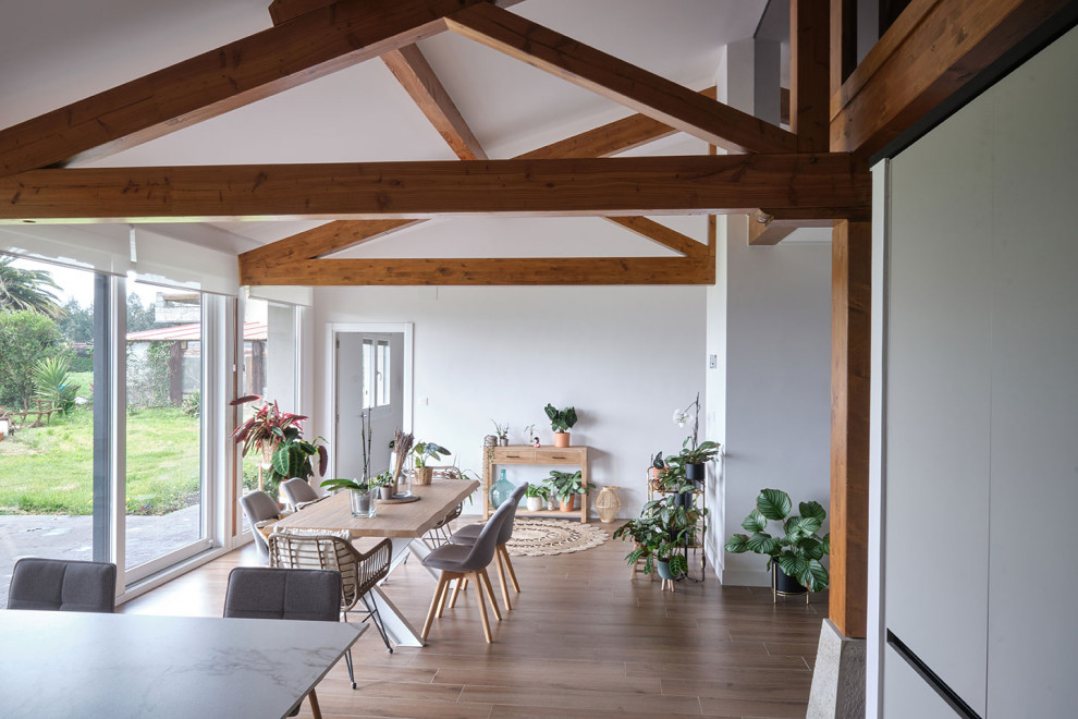 Ejemplo de comedor tradicional renovado de tamaño medio abierto sin chimenea con paredes blancas, suelo de baldosas de cerámica, suelo marrón y vigas vistas