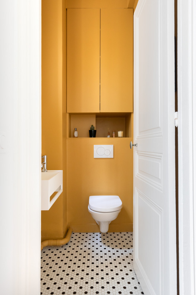 Réalisation d'un WC suspendu tradition de taille moyenne avec des portes de placard jaunes, un lavabo suspendu et un sol multicolore.