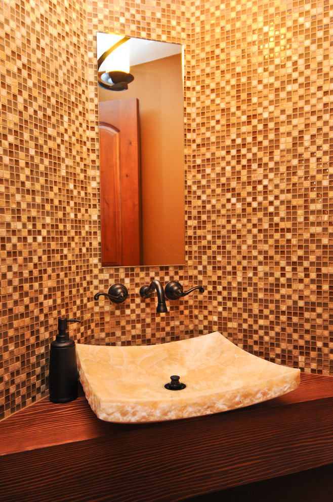 This is an example of a large country powder room in Denver with glass tile.