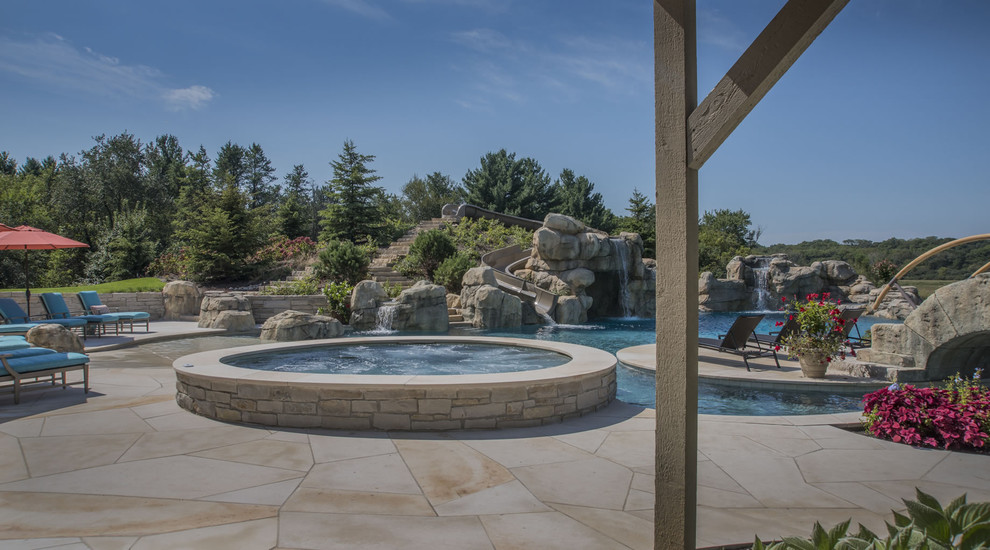 Example of a huge backyard stone and custom-shaped infinity hot tub design in Chicago