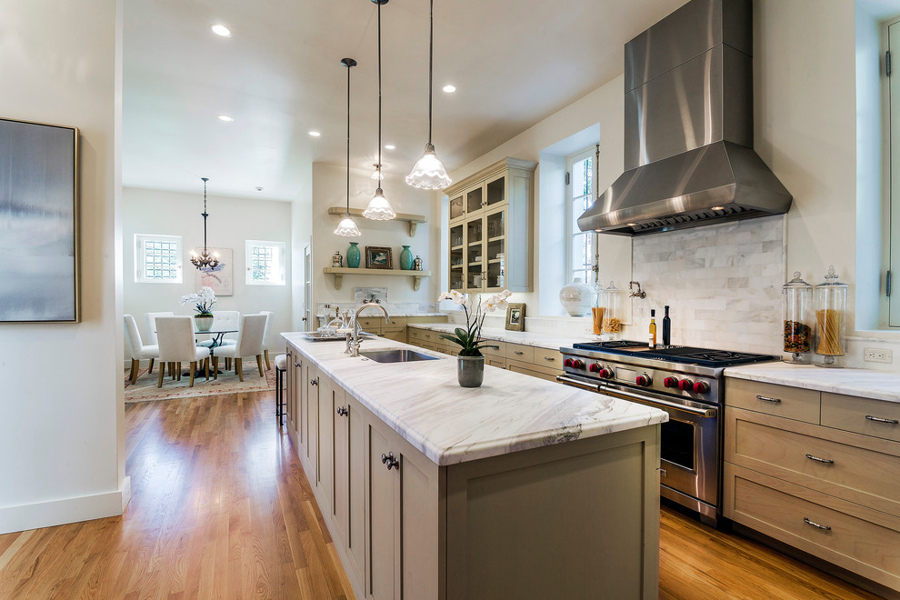 This is an example of a traditional kitchen in Santa Barbara with an undermount sink, shaker cabinets, light wood cabinets, grey splashback, stainless steel appliances, medium hardwood floors and with island.