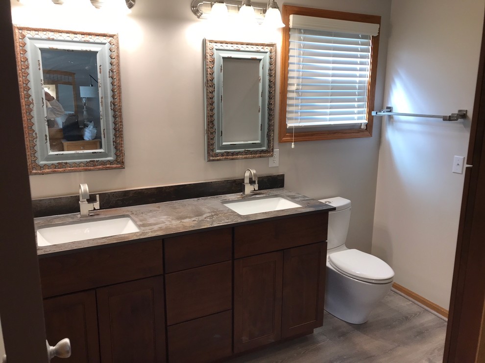 Mid-sized transitional 3/4 bathroom in Columbus with shaker cabinets, brown cabinets, an alcove shower, a two-piece toilet, orange tile, porcelain tile, grey walls, vinyl floors, an undermount sink, engineered quartz benchtops, grey floor, a hinged shower door and grey benchtops.