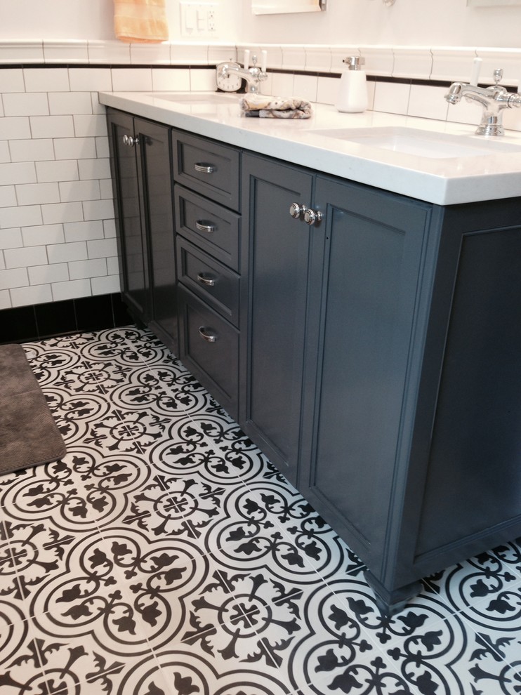 Inspiration for a mid-sized traditional master bathroom in Los Angeles with recessed-panel cabinets, blue cabinets, a drop-in tub, a corner shower, black tile, black and white tile, white tile, subway tile, white walls, ceramic floors, an undermount sink and limestone benchtops.