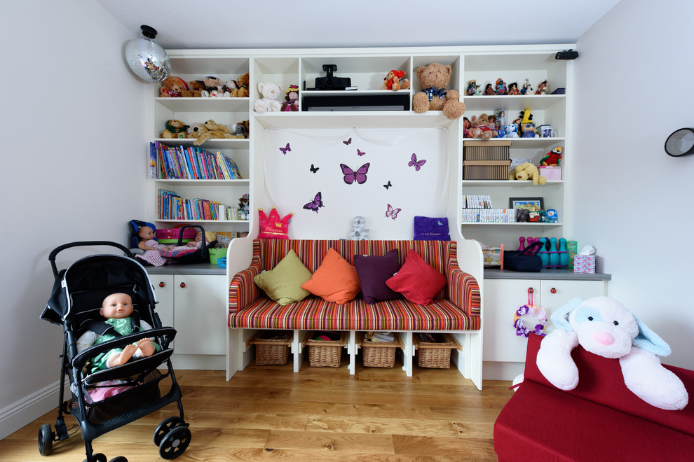 Inspiration for a transitional kids' playroom for kids 4-10 years old and girls with grey walls, medium hardwood floors and brown floor.