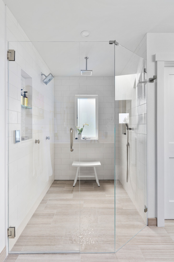 This is an example of a large transitional master bathroom in Seattle with shaker cabinets, dark wood cabinets, white tile, light hardwood floors, an undermount sink, engineered quartz benchtops, a hinged shower door, white benchtops, a niche, a double vanity and a built-in vanity.