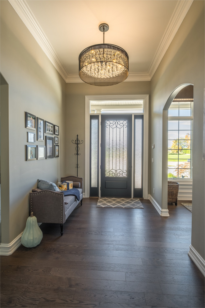 This is an example of a mid-sized country foyer in Detroit with beige walls, dark hardwood floors, a single front door, a glass front door and brown floor.
