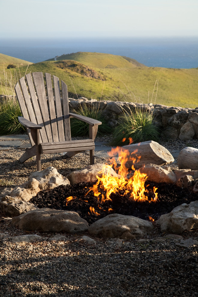 Photo of a mid-sized country backyard partial sun garden in Santa Barbara with a fire feature and gravel.