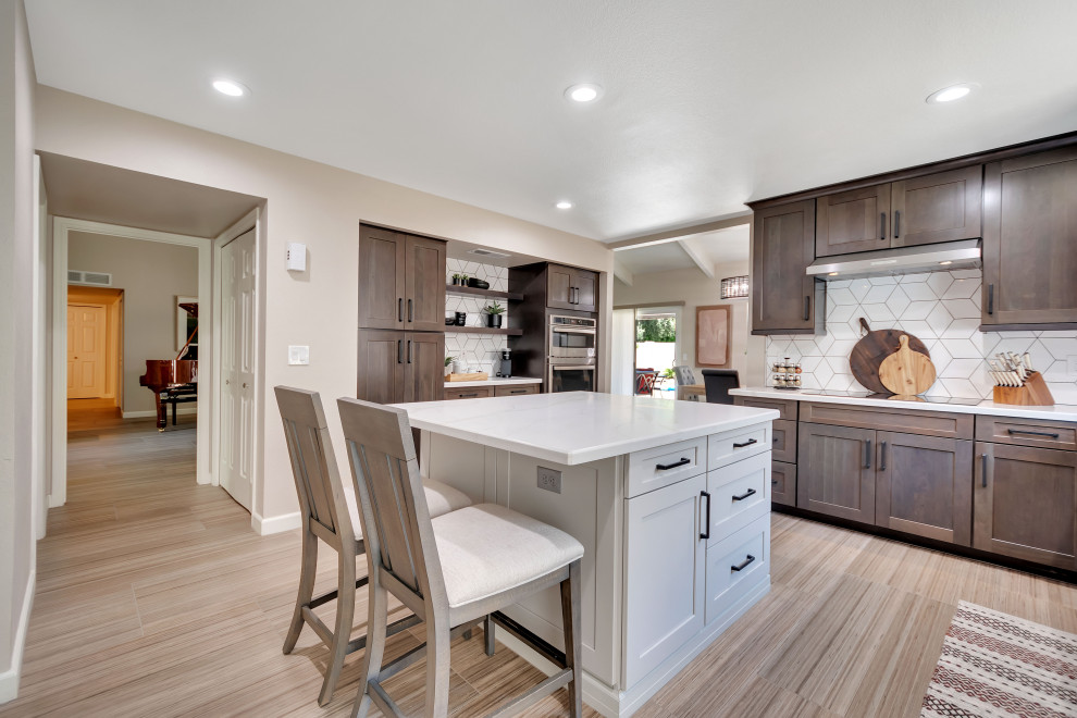 Photo of a large transitional u-shaped eat-in kitchen in Phoenix with an undermount sink, shaker cabinets, dark wood cabinets, quartzite benchtops, white splashback, porcelain splashback, stainless steel appliances, porcelain floors, with island, multi-coloured floor and white benchtop.