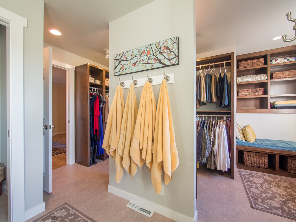 Mid-sized country gender-neutral walk-in wardrobe in Seattle with dark wood cabinets, linoleum floors, beige floor and shaker cabinets.