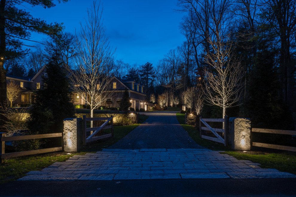 Design ideas for a large traditional front yard partial sun driveway in Boston with natural stone pavers.