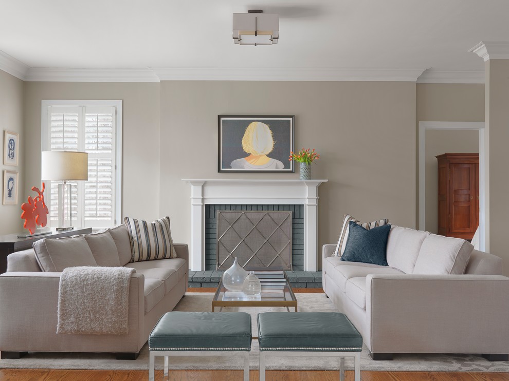 This is an example of a transitional formal enclosed living room in St Louis with beige walls, medium hardwood floors, a standard fireplace, a brick fireplace surround, no tv and orange floor.