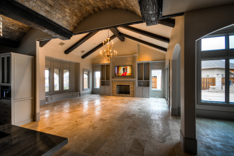 Inspiration for a large traditional open concept living room in Austin with beige walls, travertine floors, a standard fireplace, a tile fireplace surround, a built-in media wall and brown floor.