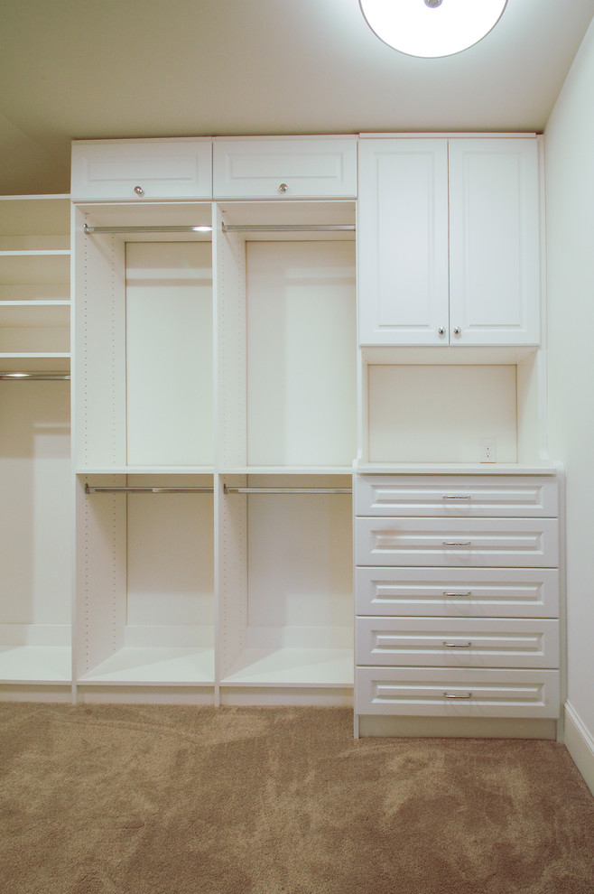 This is an example of a large transitional gender-neutral walk-in wardrobe in Minneapolis with raised-panel cabinets, white cabinets and carpet.