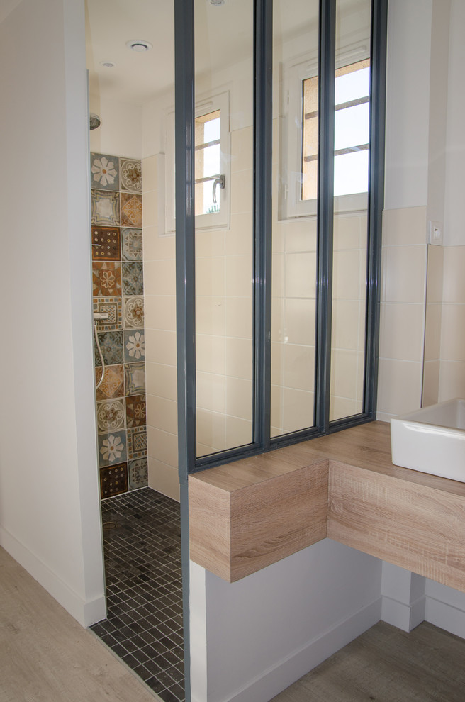 This is an example of a mid-sized contemporary master bathroom in Lyon with beaded inset cabinets, white cabinets, a drop-in tub, a curbless shower, beige tile, ceramic tile, white walls, light hardwood floors, a vessel sink, laminate benchtops and an open shower.