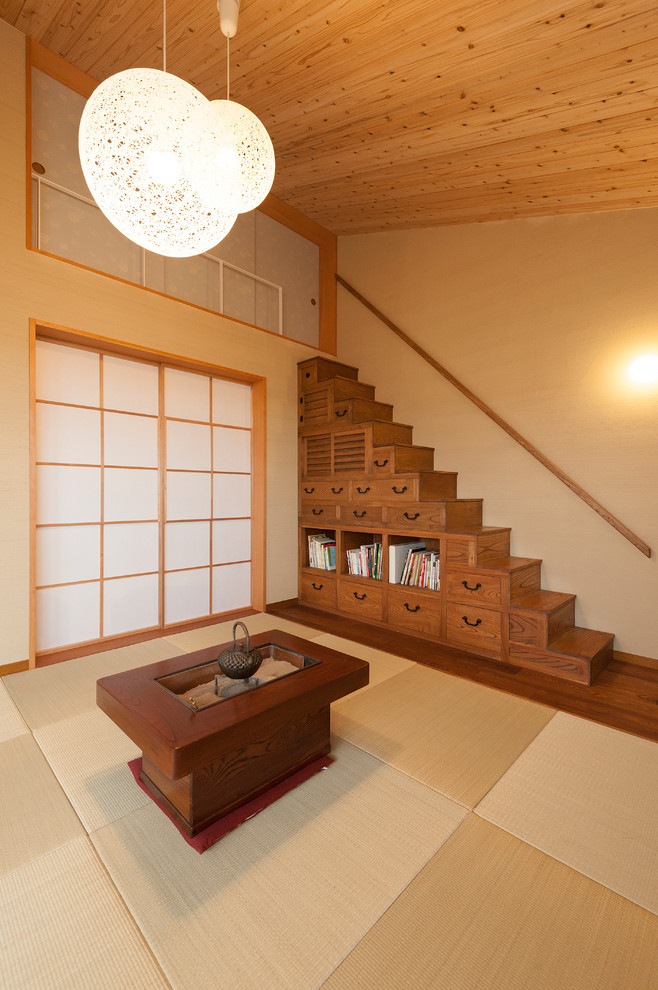 This is an example of an asian open concept living room in Kyoto with beige walls and tatami floors.