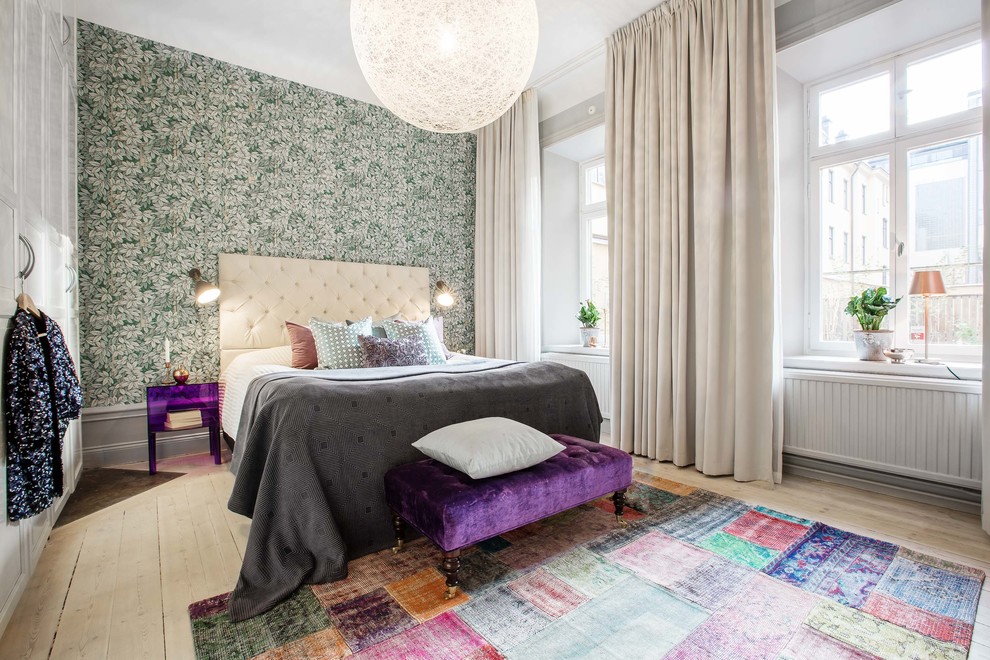 Photo of a large eclectic master bedroom in Stockholm with green walls and light hardwood floors.