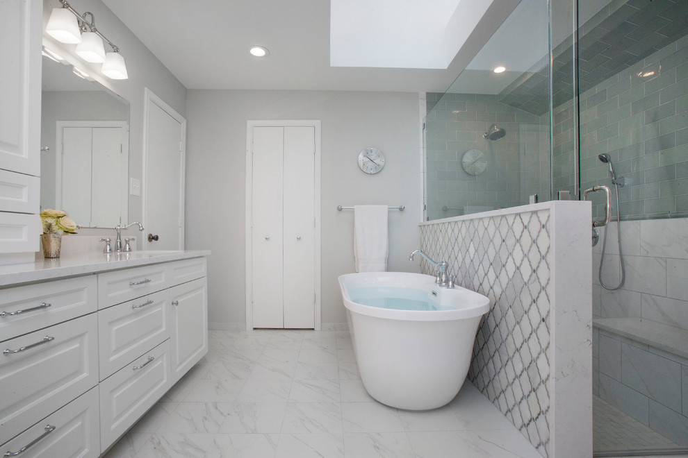 This is an example of a traditional master bathroom in Dallas with raised-panel cabinets, white cabinets, a freestanding tub, a double shower, green tile, ceramic tile, grey walls, ceramic floors, a drop-in sink, engineered quartz benchtops, white floor, a hinged shower door and white benchtops.
