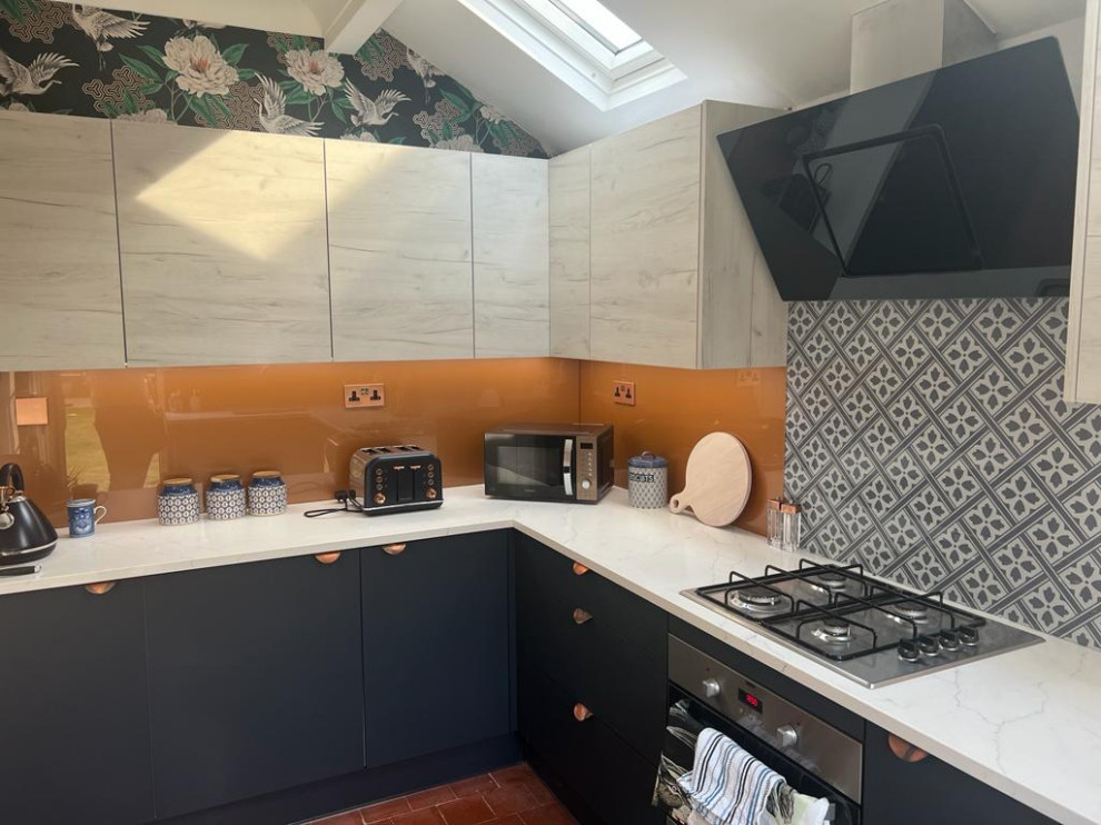 Idéer för ett avskilt, mellanstort modernt vit u-kök, med släta luckor, blå skåp, bänkskiva i kvartsit, grått stänkskydd, glaspanel som stänkskydd, svarta vitvaror, klinkergolv i terrakotta och orange golv