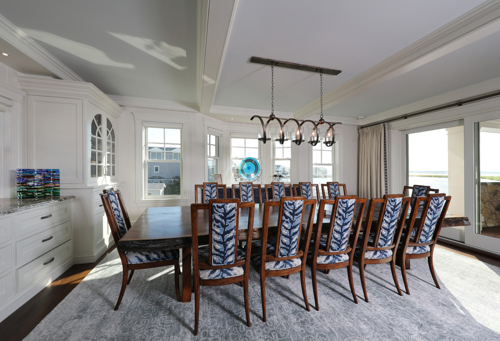 This is an example of an expansive beach style dining room in Other with white walls, dark hardwood floors, no fireplace and brown floor.