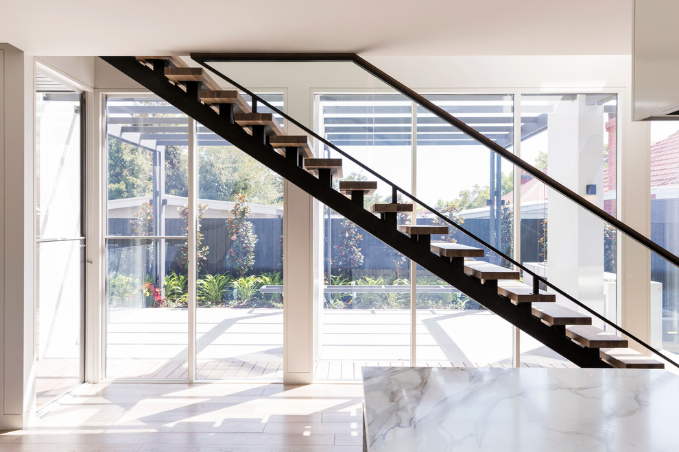 Photo of a large modern wood straight staircase in Melbourne with open risers.
