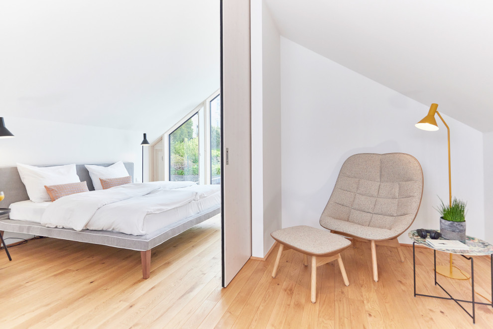 Пример оригинального дизайна: спальня среднего размера, в белых тонах с отделкой деревом на антресоли в скандинавском стиле с белыми стенами и светлым паркетным полом