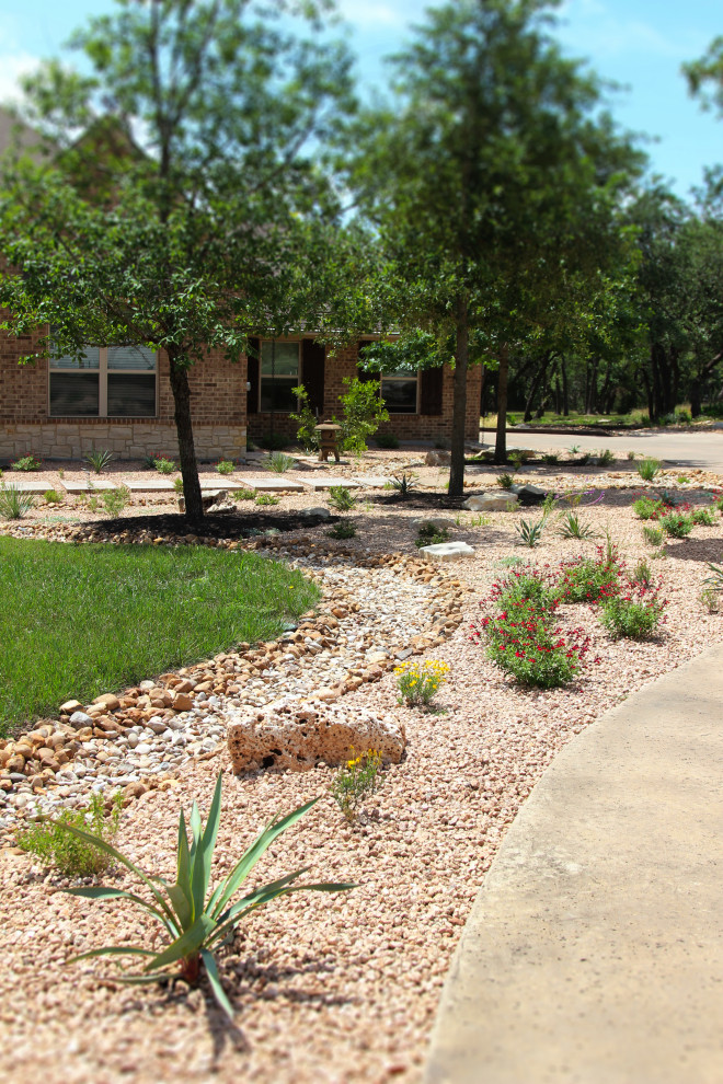 Photo of a large front yard full sun driveway in Austin with river rock and with lawn edging.