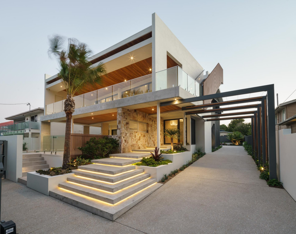 Inspiration for a large beach style one-storey concrete multi-coloured house exterior in Sunshine Coast with a flat roof.