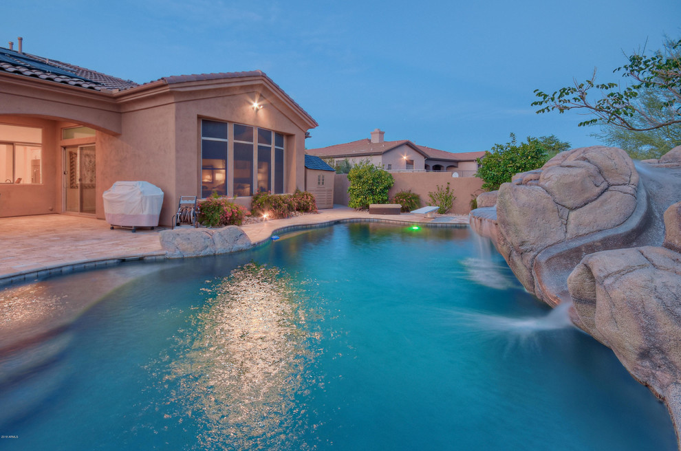 Mid-sized backyard custom-shaped pool in Phoenix with a water slide and tile.