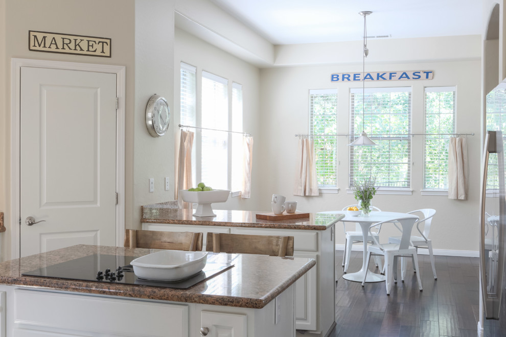 Example of a mid-sized transitional u-shaped dark wood floor and brown floor eat-in kitchen design in Phoenix with a drop-in sink, raised-panel cabinets, white cabinets, granite countertops, brown backsplash, stainless steel appliances and two islands