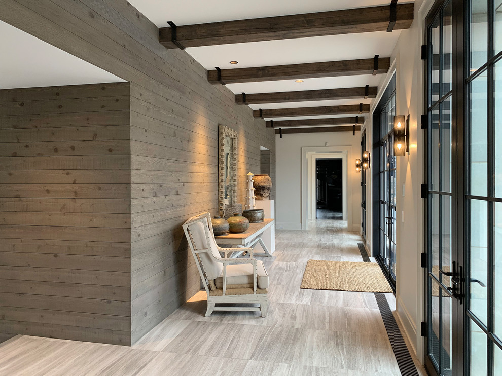 Inspiration for an expansive modern foyer in Chicago with grey walls, porcelain floors, a double front door, a black front door, multi-coloured floor, exposed beam and planked wall panelling.