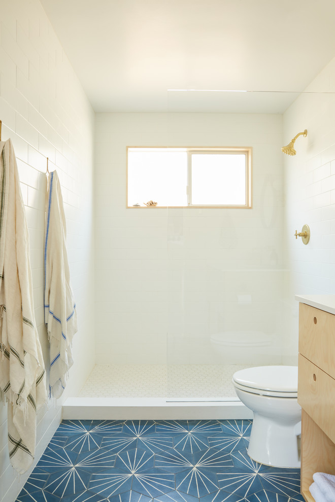 Photo of a midcentury bathroom in Los Angeles with flat-panel cabinets, light wood cabinets, an open shower, ceramic floors and blue floor.