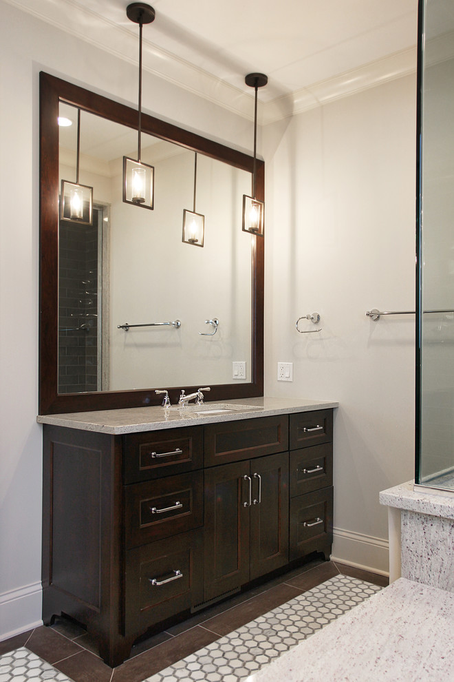 Photo of a mid-sized transitional master bathroom in Chicago with recessed-panel cabinets, dark wood cabinets, an undermount tub, a corner shower, a two-piece toilet, an undermount sink, ceramic tile, grey walls, marble floors, gray tile, quartzite benchtops, white floor, a hinged shower door and grey benchtops.