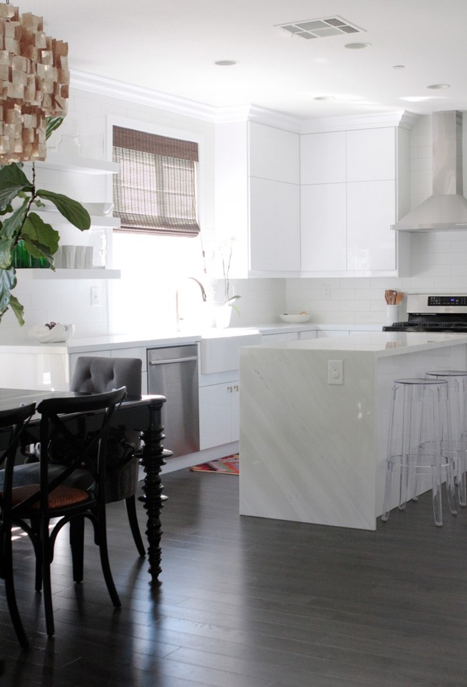 This is an example of a contemporary open plan kitchen in Orange County with white cabinets and with island.