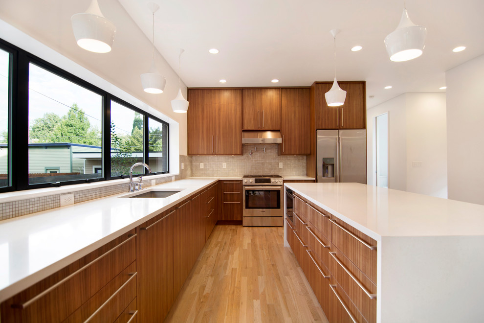 This is an example of a large contemporary l-shaped kitchen in Denver with an undermount sink, flat-panel cabinets, dark wood cabinets, quartz benchtops, beige splashback, mosaic tile splashback, stainless steel appliances, medium hardwood floors and with island.