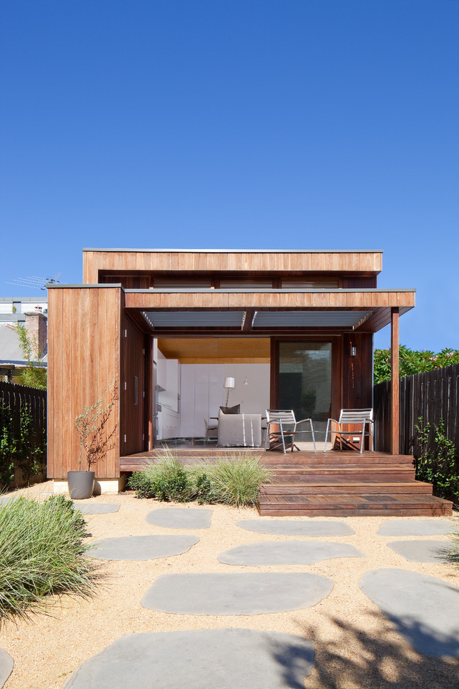 This is an example of a mid-sized contemporary exterior in Sydney with wood siding and a flat roof.