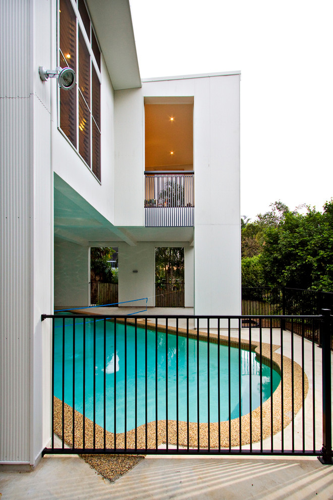 This is an example of a large modern backyard custom-shaped pool in Brisbane.