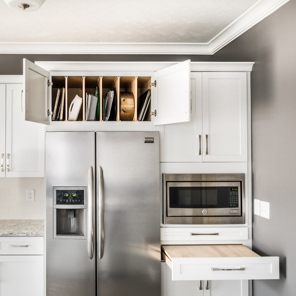 Mid-sized transitional galley vinyl floor and beige floor open concept kitchen photo with an undermount sink, recessed-panel cabinets, white cabinets, quartz countertops, white backsplash, stone tile backsplash, stainless steel appliances, a peninsula and multicolored countertops