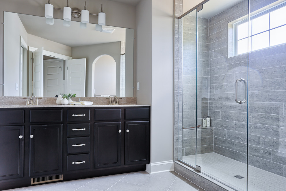 Alcove shower - large transitional master gray tile and porcelain tile ceramic tile alcove shower idea with recessed-panel cabinets, dark wood cabinets, gray walls and marble countertops