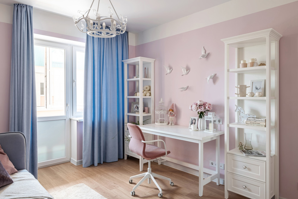 This is an example of a small country kids' room for girls with pink walls, laminate floors and beige floor.