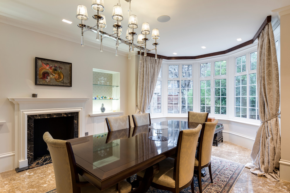 Photo of a large contemporary separate dining room in London with white walls, marble floors, a standard fireplace and a stone fireplace surround.