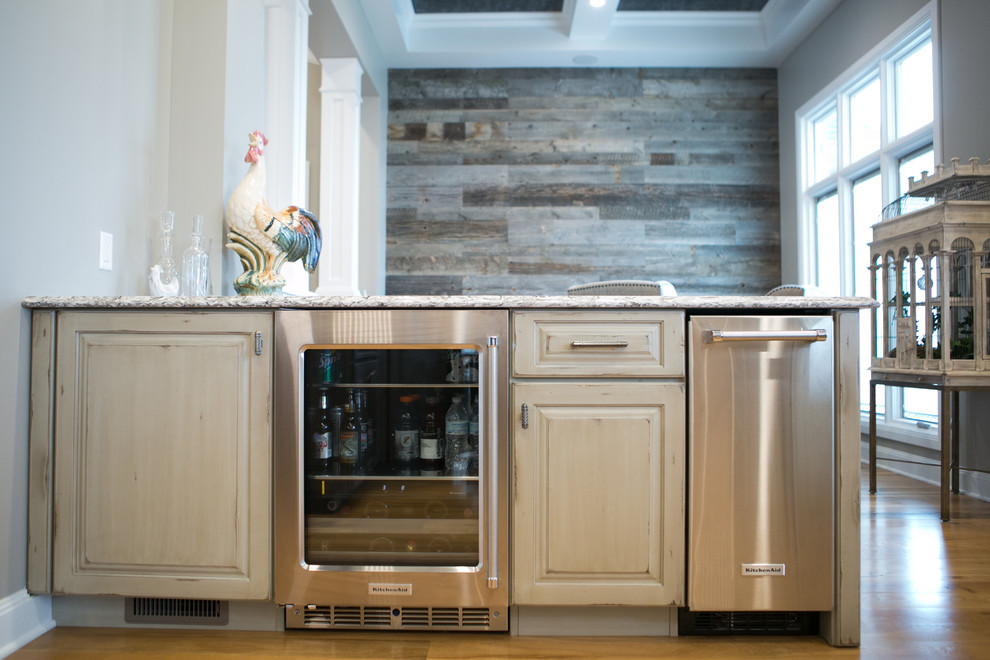 Kitchen - large transitional u-shaped medium tone wood floor and brown floor kitchen idea in Indianapolis with a farmhouse sink, raised-panel cabinets, dark wood cabinets, granite countertops, white backsplash, subway tile backsplash, paneled appliances, an island and multicolored countertops