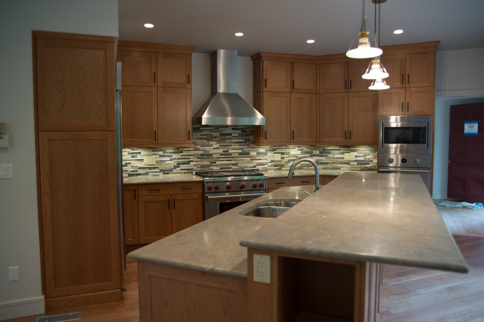 Large transitional l-shaped medium tone wood floor eat-in kitchen photo with a double-bowl sink, recessed-panel cabinets, medium tone wood cabinets, concrete countertops, multicolored backsplash, matchstick tile backsplash, stainless steel appliances and an island