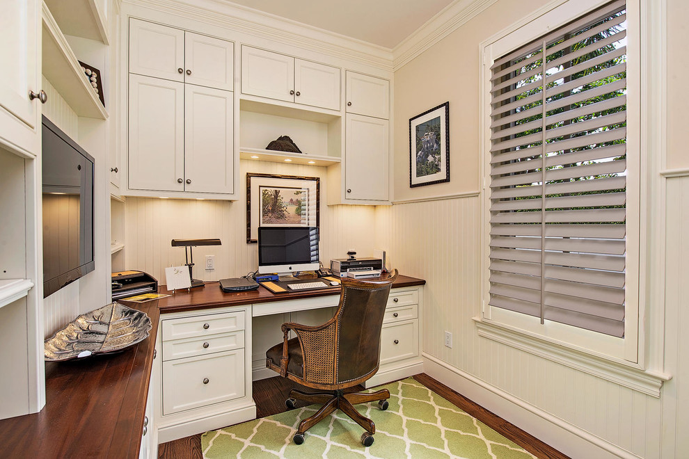 Small tropical study room in Miami with white walls, dark hardwood floors, no fireplace and a freestanding desk.