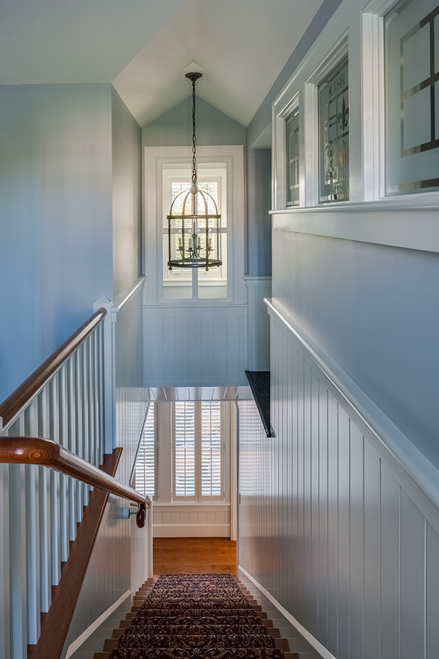 Mid-sized traditional carpeted straight staircase in Boston with carpet risers and wood railing.