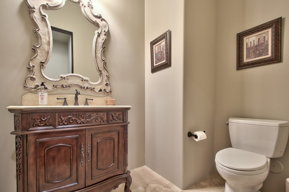 Inspiration for a mid-sized powder room in Phoenix with furniture-like cabinets, dark wood cabinets, a two-piece toilet, grey walls, travertine floors, an undermount sink, travertine benchtops, beige floor and beige benchtops.