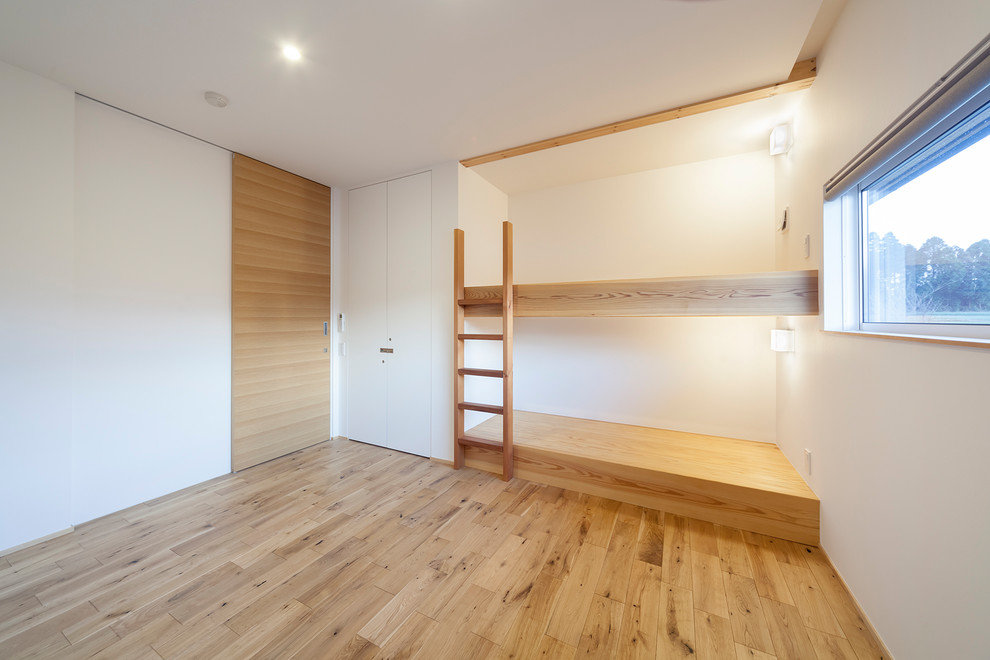 他の地域にあるおしゃれな子供部屋 (白い壁、茶色い床) の写真