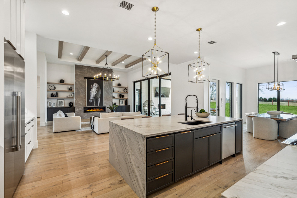 This is an example of a large contemporary l-shaped eat-in kitchen in Dallas with an undermount sink, shaker cabinets, white cabinets, quartzite benchtops, grey splashback, marble splashback, stainless steel appliances, light hardwood floors, with island, white floor and grey benchtop.