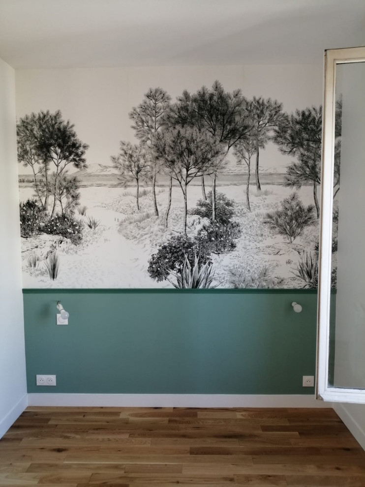 Immagine di una camera da letto contemporanea con pareti verdi, parquet chiaro e carta da parati